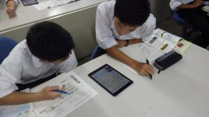 学校でタブレットを使って学習する二人の生徒