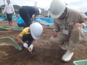 職員が参加者に指導しながら作業している写真です